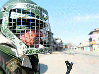 A CRPF jawan stands guard at a check point in Srinagar on Wednesday