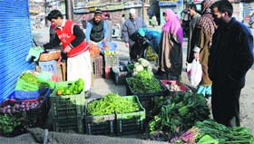 People buy vegetables in Srinagar on Wednesday. Curfew was relaxed in the city under five police stations