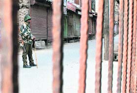 A CRPF soldier guards a street during curfew in Srinagar on Wednesday
