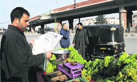 A roadside vendor reads an Urdu newspaper after the government lifted the ban on media publications in Srinagar on Wednesday