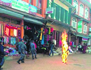 Police rush to a Tibetan monk who set himself on fire at the Boudhanath stupa in Kathmandu on Wednesday.
