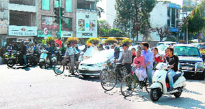 In the absence of a slip road, vehicles, willing to take a right turn, wait for the green light at an intersection in Amritsar. 