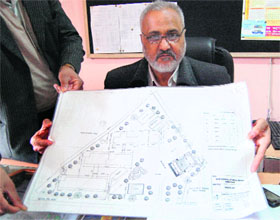 An AIT official shows the original site plan of Government Saragarhi Senior Secondary School.