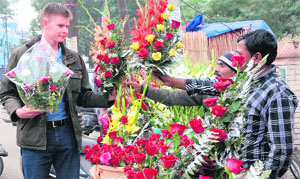 A foreigner purchases flowers to celebrate the day in Amritsar on Thursday. 