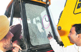 MC employee points at a broken glass of a JCB machine on Thursday.