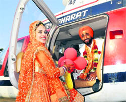Newlyweds Aman Araich and Simrat Kaur board a chopper in Mohali on Thursday.