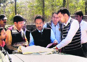SDM (Gurgaon-South) Vivek Kalia and other officials examine land record while executing eviction orders at Punjabi singer Daler Mehndis (inset) farmhouse in Sohna on Thursday