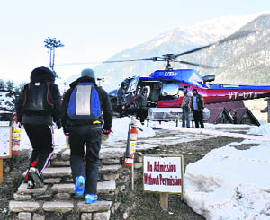Foreigners head towards the chopper for heli-skiing in high mountains of Manali. 