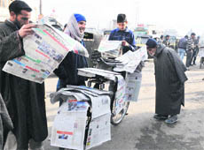 Locals reading newspapers published from Srinagar at Hari Singh High Street in Srinagar after curfew was lifted from some parts of the Kashmir valley in Srinagar on Thursday. 