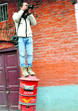 A photographer stands on a post box to click a picture in Srinagar on Thursday.