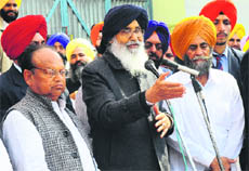 Chief Minister Parkash Singh Badal addresses a gathering along with SAD nominee Joginder Pal Jain (left) in Bukkanwal village of Moga on Thursday.