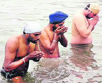 Devotees take a holy dip in the sarovar of Gurdwara Chheharta Sahib on Basant Panchami in Amritsar on Friday