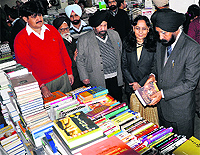 Vice- Chancellor of Guru Nanak Dev University AS Brar looks at books during an exhibition in Amritsar on Friday