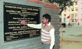 A worker wipes clean the foundation stone of the Alternate Dispute Redressal (ADR) Centre in Bathinda on Friday.