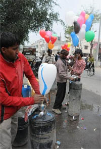 Sellers busy filling hydrogen gas in the balloons that are flown by kids on Basant Panchami.