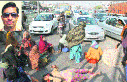 Relatives of the deceased Rajesh Bittu (inset) block traffic on the highway as a mark of protest in Dera Bassi on Friday. Tribune photo: Nitin Mittal