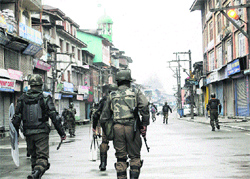 CRPF personnel patrol a deserted street at Maisuma near Lal Chowk in Srinagar on Friday. Tribune photo: Amin War