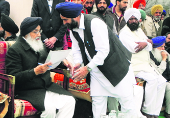 Chief Minister PS Badal accepts a charter of demands from Landeke village sarpanch Amarjit Singh in Moga on Friday.