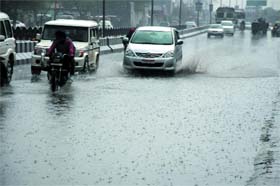 Vehicles make their way through a waterlogged road after rains lashed Bathinda on Saturday