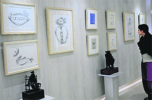 A visitor admires the paintings displayed at Art Portfolio