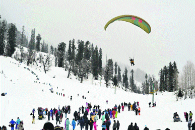 Tourists enjoy paragliding in the Solang valley near Manali 