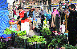 Locals buy vegetables after curfew was lifted from Srinagar on Sunday