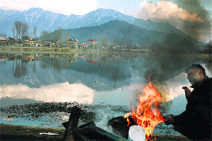 A man warms himself around a bonfire in Srinagar on Sunday. 