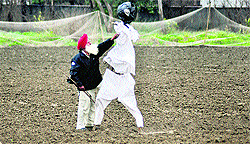 A farmer adjusts the clothes of a scarecrow in his fields at Ludhiana
