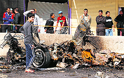 Residents at the site of a car bomb blast at Ameen district in Baghdad on Sunday