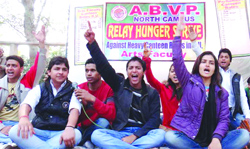 Activists of ABVP shout slogans during their dharna against high rates in canteens at Delhi University on Monday. Tribune photo 