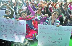 Employees of HIV/AIDS control programme shout slogans during a demonstration to regularise their jobs at Jantar Mantar in New Delhi on Monday. 