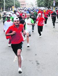Participants run in half marathon on the completion of the Road safety month organised by the district police in Karnal.