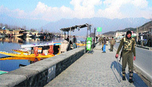 A CRPF jawan patrols the Dal Lake area on Monday. 