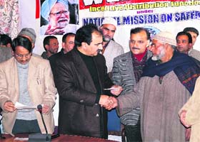 Kashmir Agriculture Director Farooq Ahmad Lone hands over a cheque to a saffron grower in Srinagar on Monday