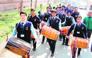 Students carry drums and singers along with artistes carry out an awareness march to mark Mother Tongue Day, organised by Folklore Research Academy, in Amritsar on Tuesday.