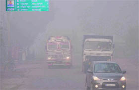 Vehicles ply on NH-72 at a snails pace as foggy conditions prevailed on Tuesday morning in Haridwar.