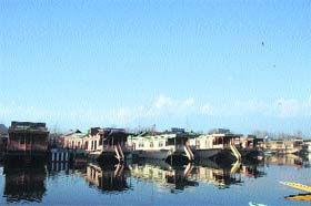 Mirror Image: Houseboats are reflected in the waters of the Dal Lake on Tuesday