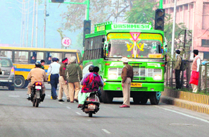 Policemen stop a bus from proceeding ahead in Amritsar on Wednesday.
