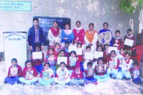 The students and staff of Government Elementary School, Gill Patti, with the magazine released at the function