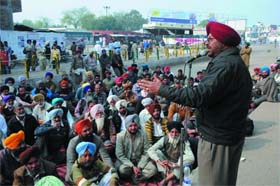 PRTC workers gather under the banner of the AITUC and stage a gate rally at the bus stand
