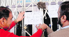 Bank employees paste notices on the gate of a bank branch in Sector 17, Chandigarh, during a strike on Wednesday. Tribune photo: Manoj Mahajan