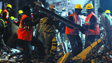 The Delhi police and Disaster Management personnel try to remove the rubble at Tahirpur near GTB Hospital in New Delhi on Wednesday.