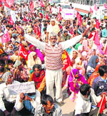 Activists of the trade unions block road near Lal Batti Chowk in Sirsa on Wednesday.
