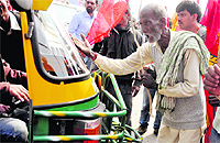An elderly protester argues with an auto driver