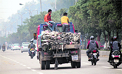 An MC vehicle carries garbage without cover on a busy road in Jammu on Thursday