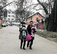 A tourist couple takes a walk with their child in Srinagar on Thursday