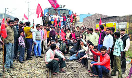 Protesters block the rail track near Dhandari Kalan railway station in Ludhiana on Thursday.