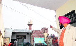 Gurbachan Singh, head teacher of Government Elementary School, Mustafabad, shows high-tension wires passing over the school in Amritsar on Friday.