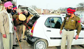 Policemen check a car in Moga.
