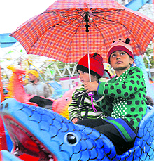 Children enjoy a ride during rain